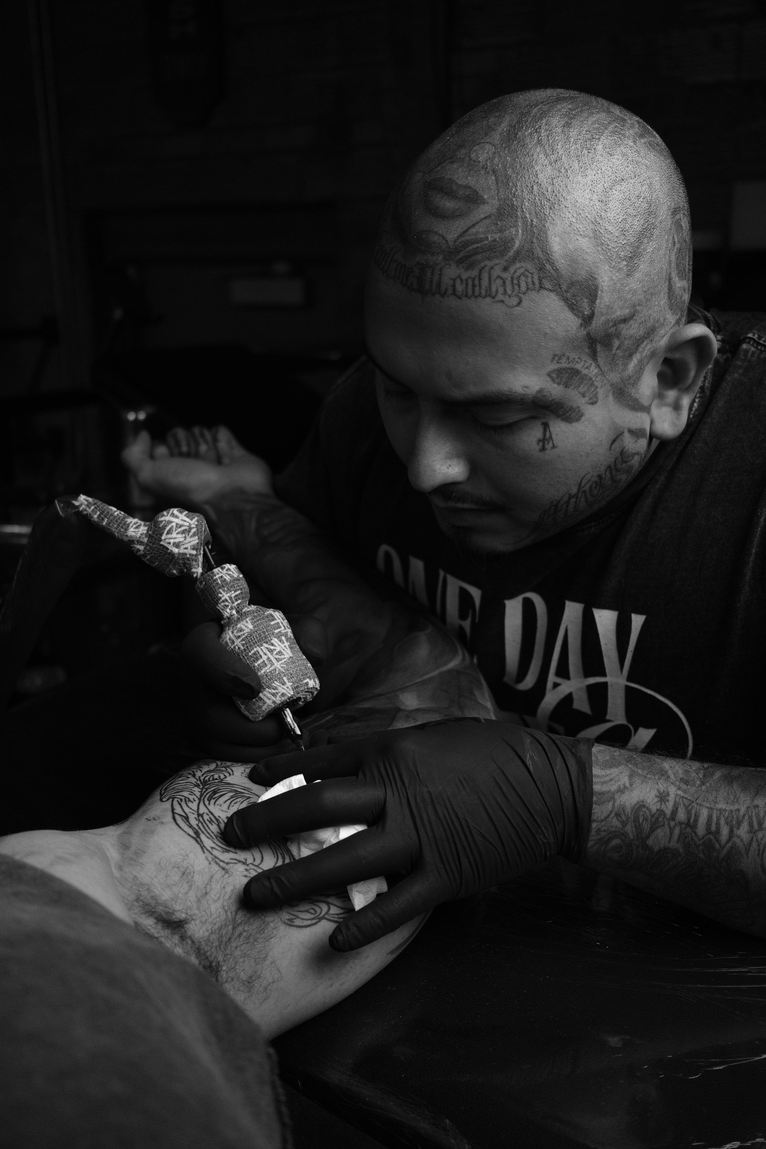 Working artists watching Mitchell tattoo a client live